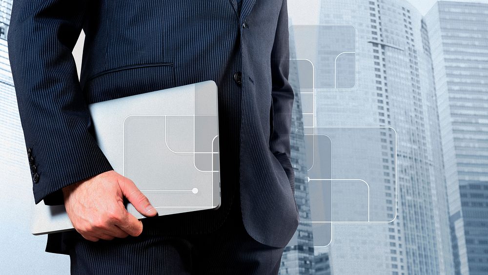 Businessman holding a laptop city background