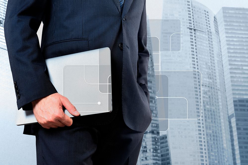 Businessman holding a laptop city background