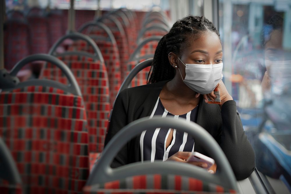 African American woman wearing mask on the bus while traveling on public transportation in the new normal