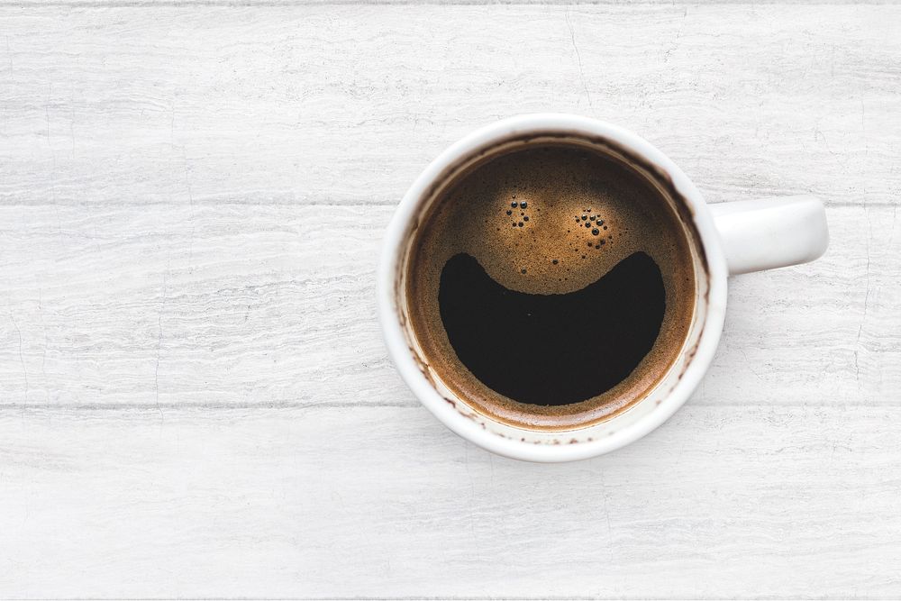 Aesthetic Americano coffee cup on a white wooden table