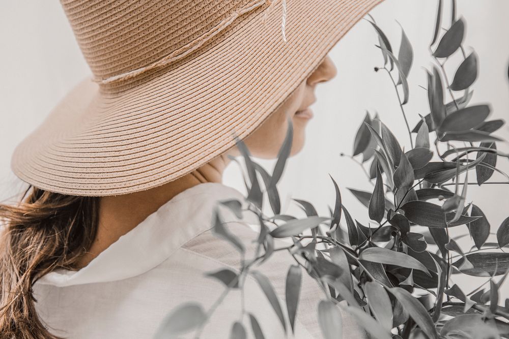 Woman in sunhat, exploring garden closeup portrait