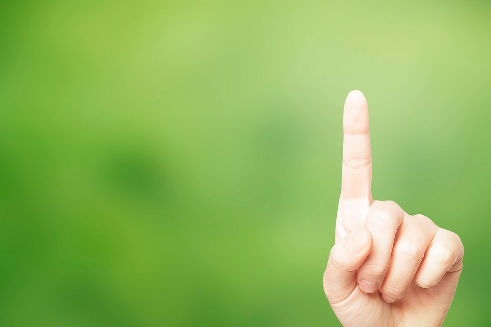 Hand pointing on green background