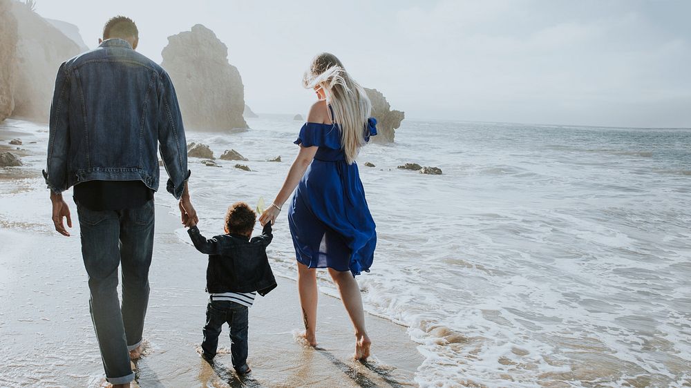 Interracial family walking along the beach in California