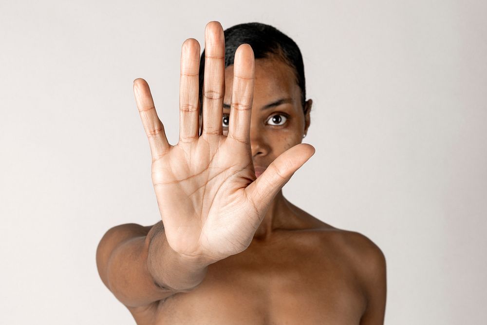 Bare chested black woman doing stop hand gesture