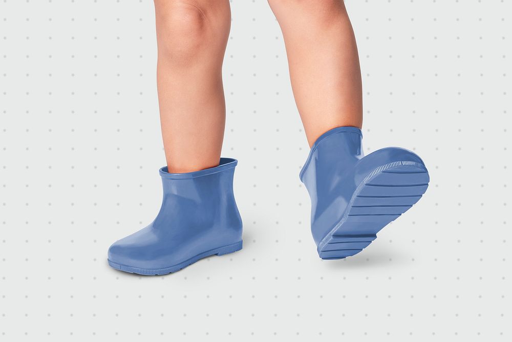 Kid with blue rubber boots studio shot