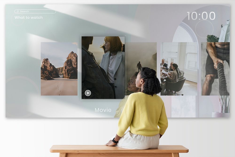 Woman watching movie projecting on wall rear view