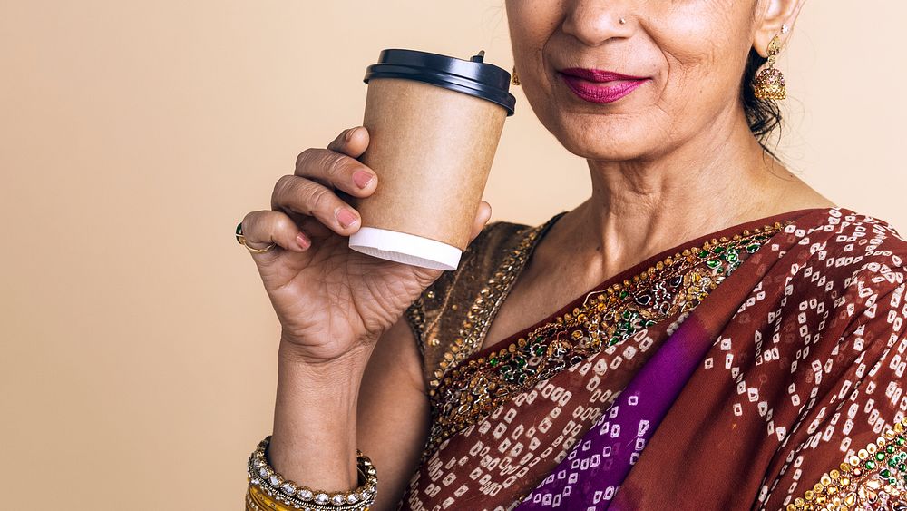 Indian woman in a saree drink coffee from a paper cup mockup 