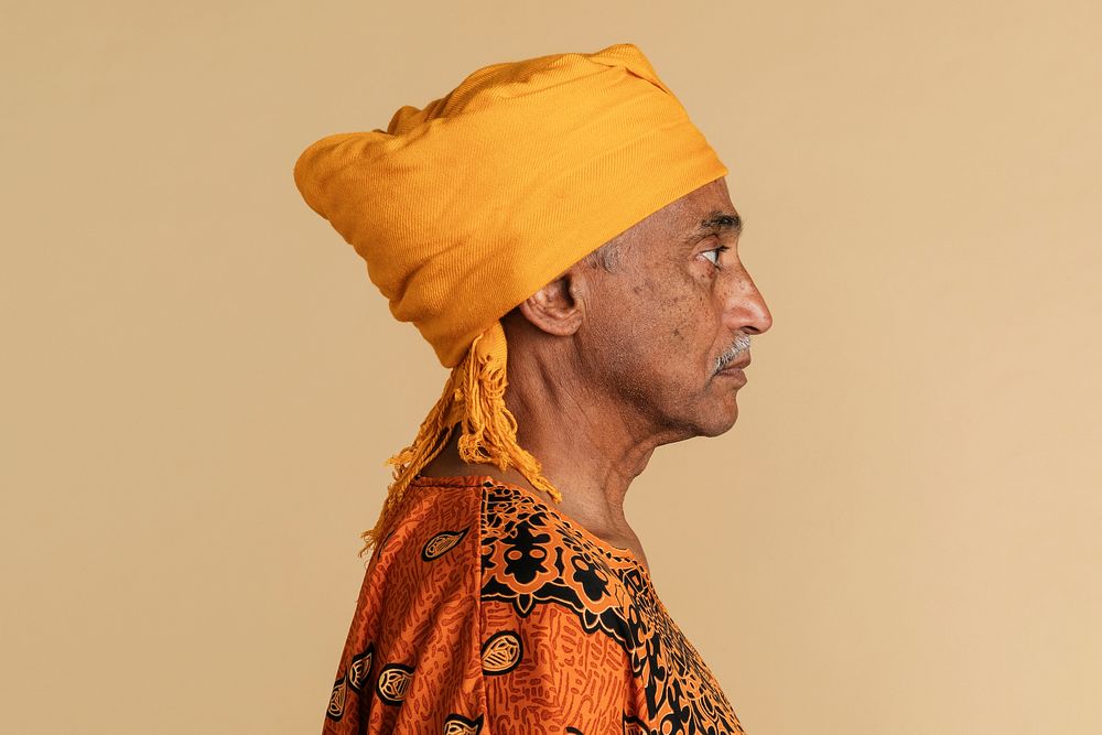 Mixed Indian senior man wearing a yellow turban facing sideways