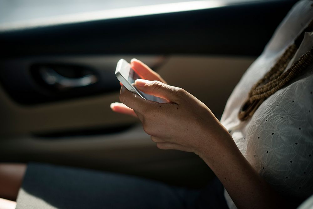 Businesswoman checking her phone during a car ride