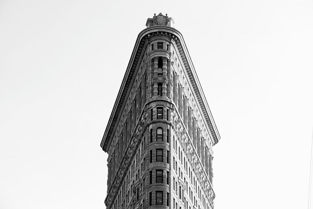 Black and white photo looking up at the Flatiron Building in New York City. Original public domain image from Wikimedia…