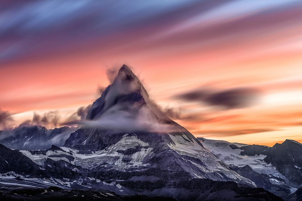 Snowcapped mountain peak on a cloudy sunrise in Matterhorn. Original public domain image from Wikimedia Commons
