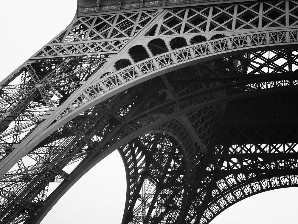 Bottom of the Eiffel Tower on a cloudy day. Original public domain image from Wikimedia Commons