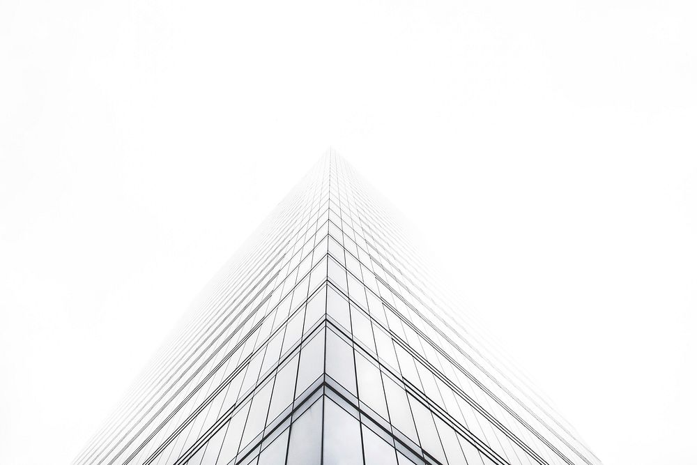 An office building with a glass facade shrouded in fog. Original public domain image from Wikimedia Commons