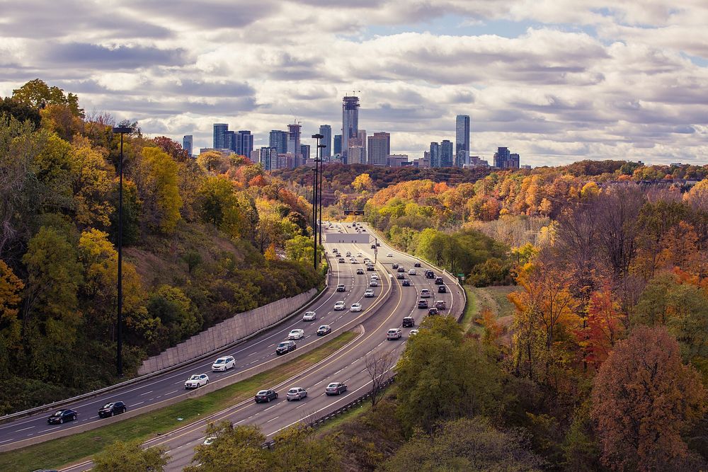 Long shot of busy daytime highway traffic with autumnal trees at Leaside Bridge. Original public domain image from Wikimedia…
