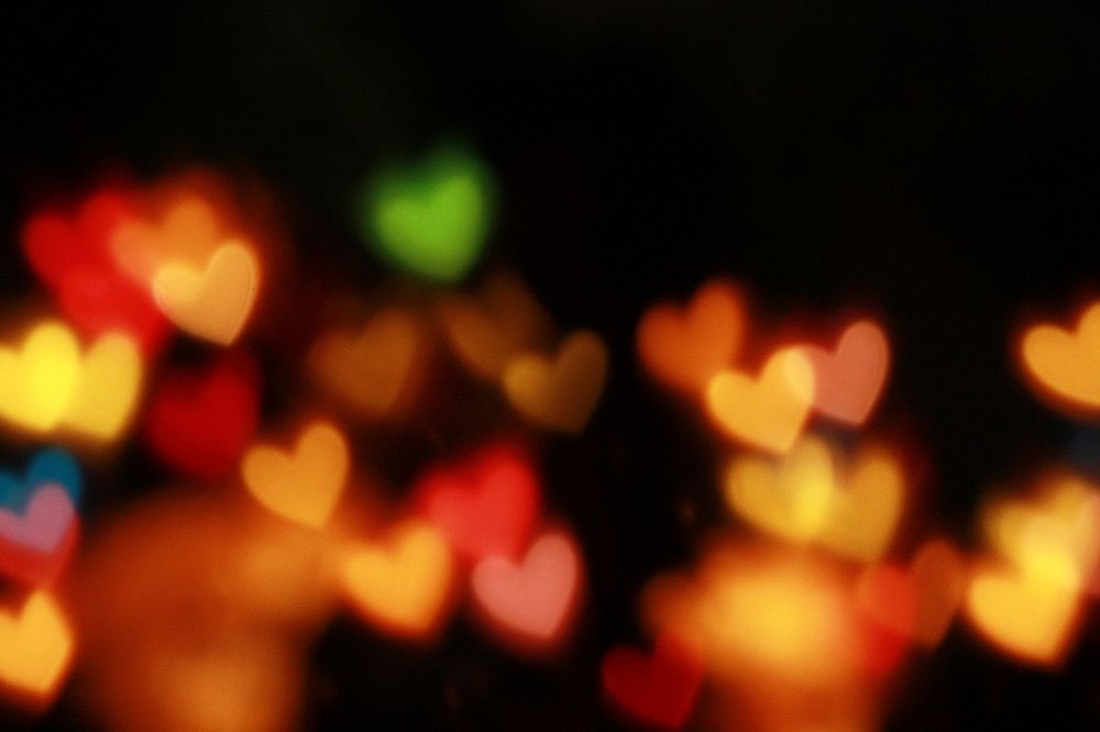 Illuminated multi-colored hearts against a black backdrop. Original public domain image from Wikimedia Commons