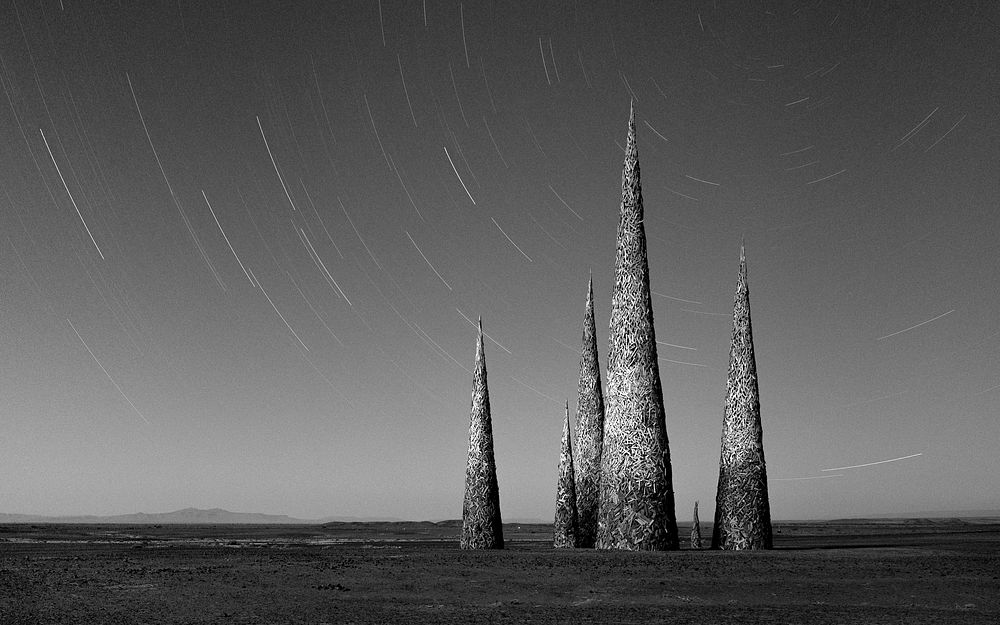 Subterrafuge spires at AfrikaBurn in monotone Original public domain image from Wikimedia Commons