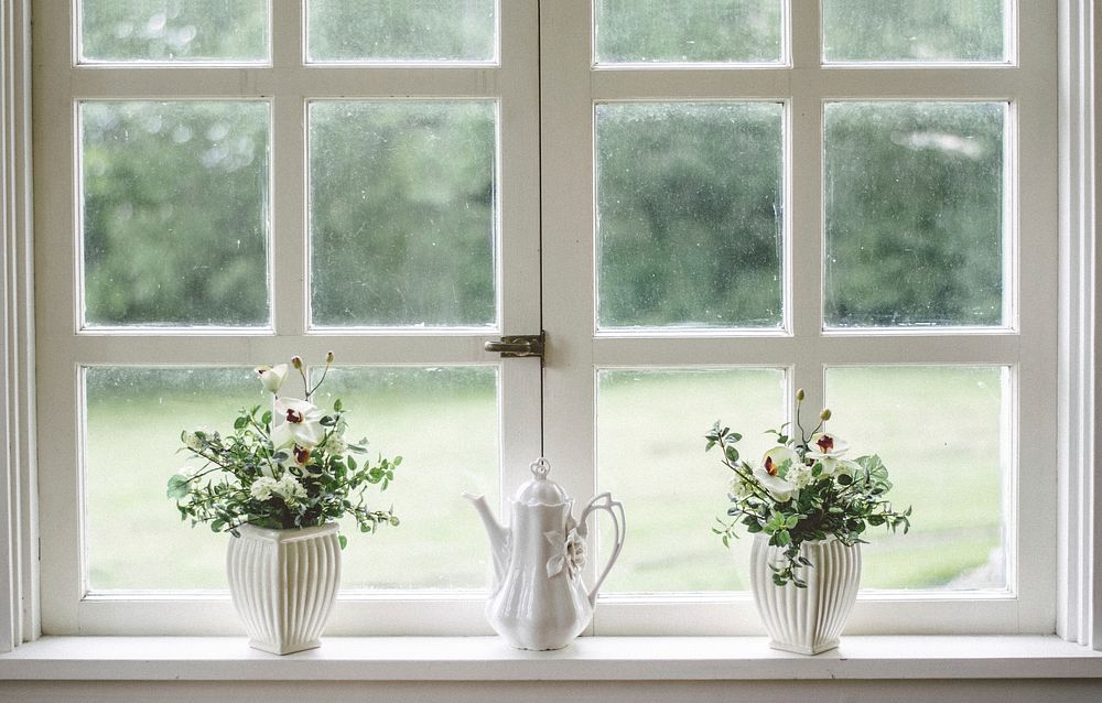 A porcelain teapot between two potted plants on a windowsill. Original public domain image from Wikimedia Commons