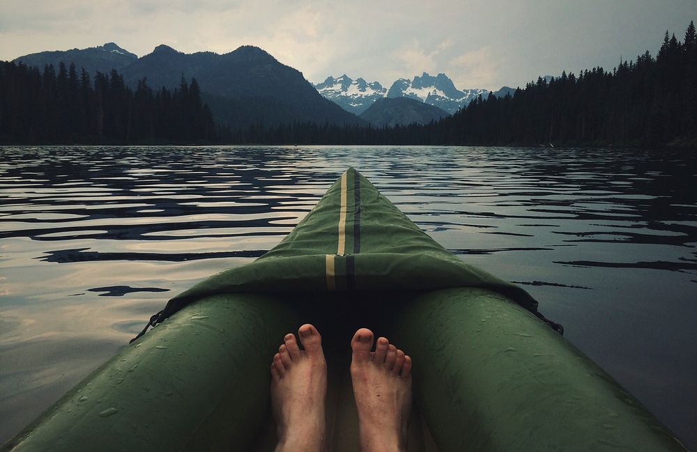 The view of a person's feet and the front of their canoe on a lake. Original public domain image from Wikimedia Commons