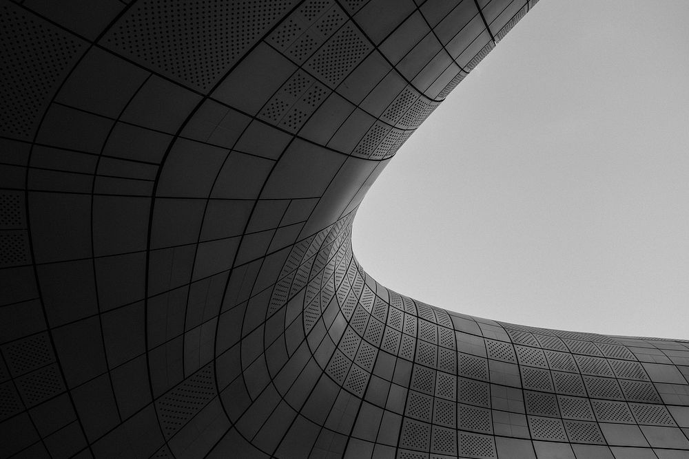 A smooth round curve in a gray building facade. Original public domain image from Wikimedia Commons