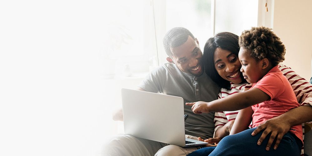 Happy black family and toddler pointing at a laptop screen design space