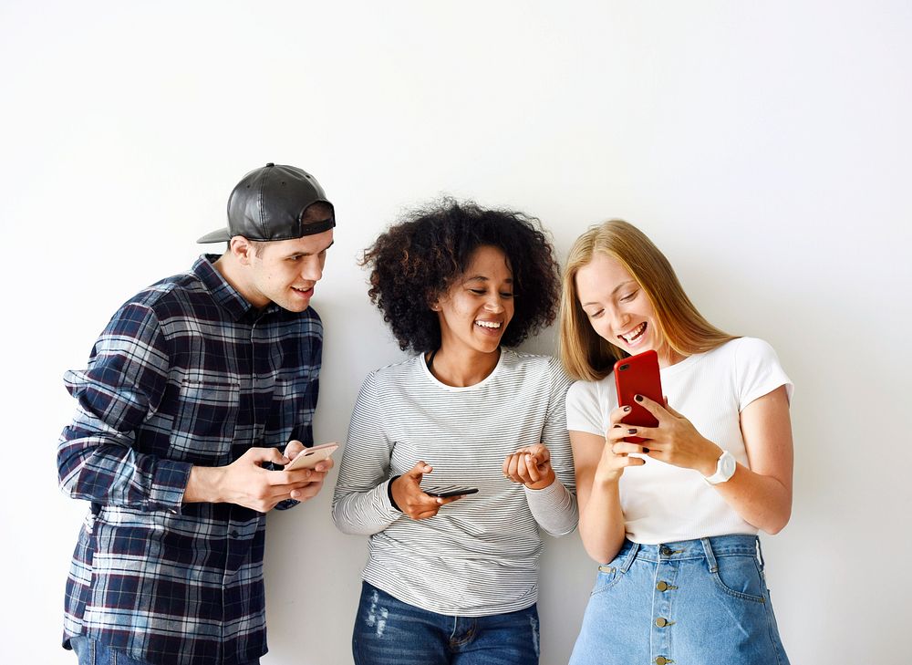 Happy friends using smartphone together social media concept