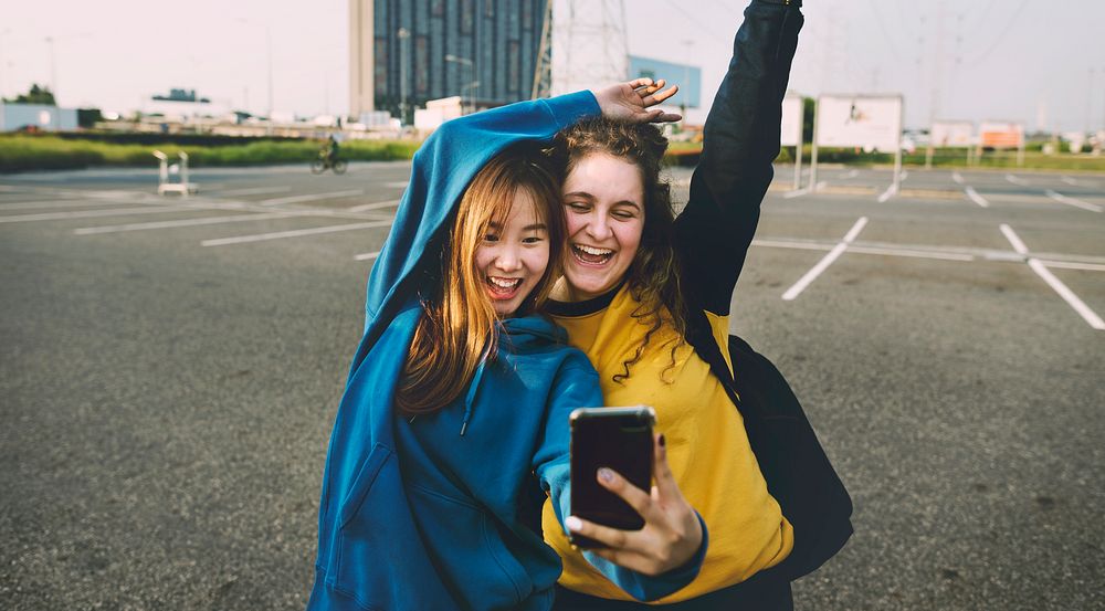 Girl friends smiling and taking a selfie together