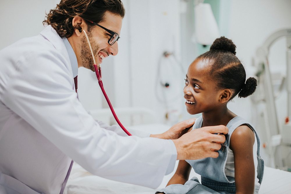 Friendly pediatrician checking a little girls heart