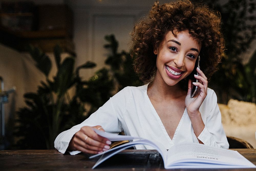 Cheerful woman talking on the phone in a cafe