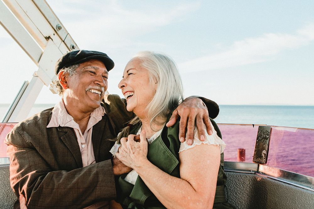 Cheerful senior couple enjoying a Ferris wheel by the Santa Monica pier