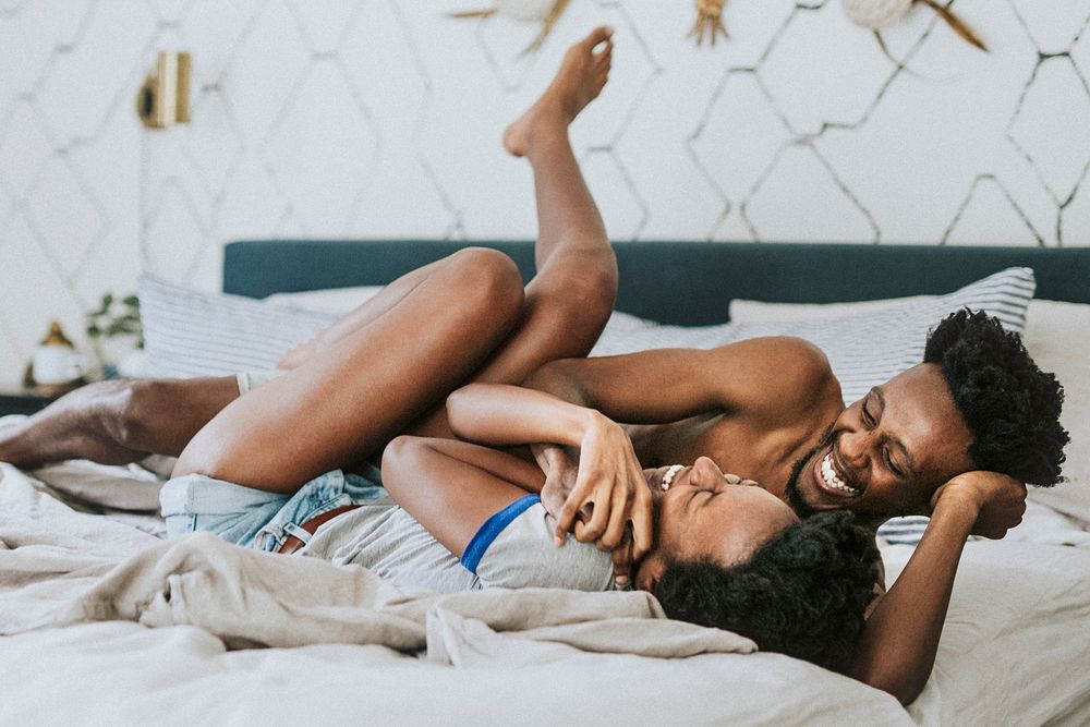 Cute happy black couple playing in bed