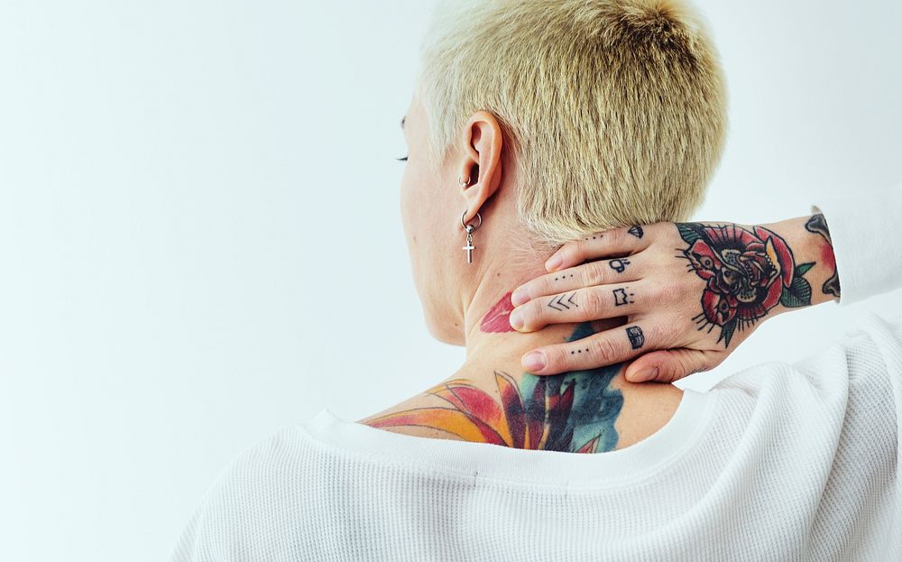 Tattooed woman touching her neck