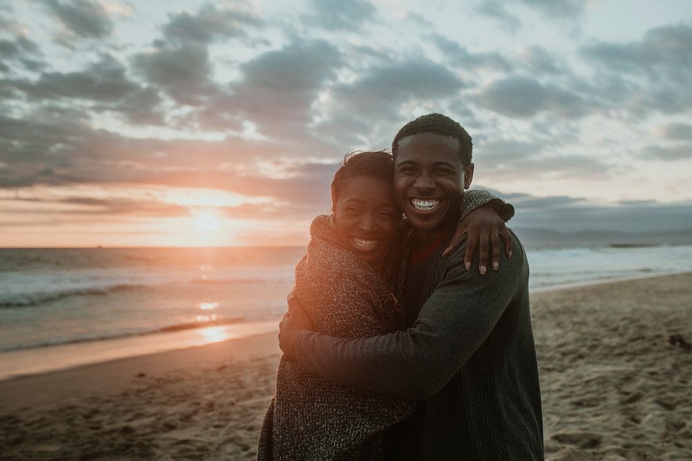 Cheerful couple hugging at the beach
