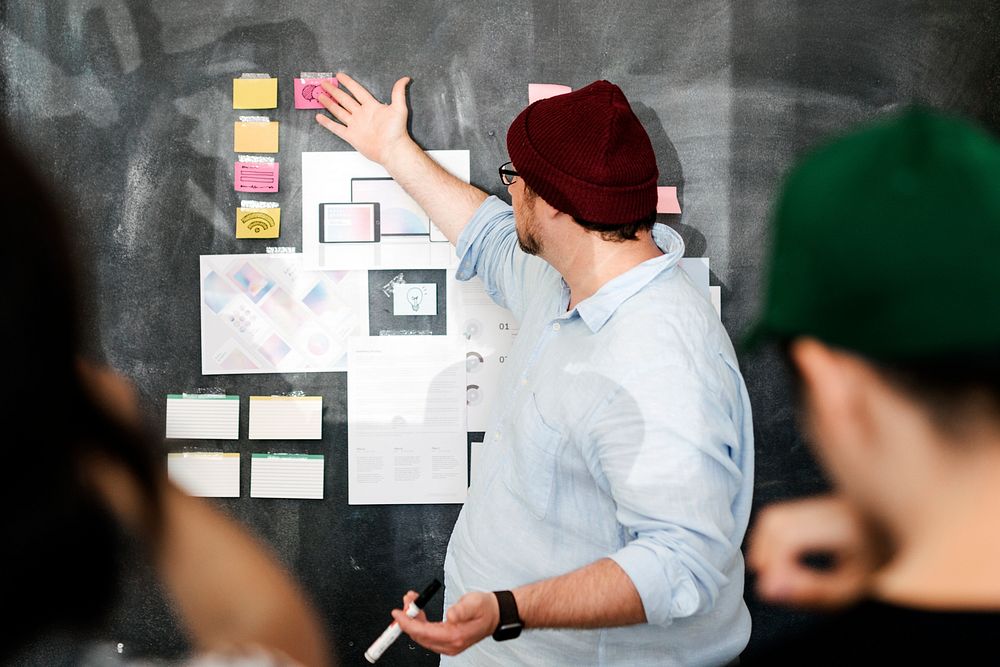 Leader in a startup company brainstorming using a blackboard