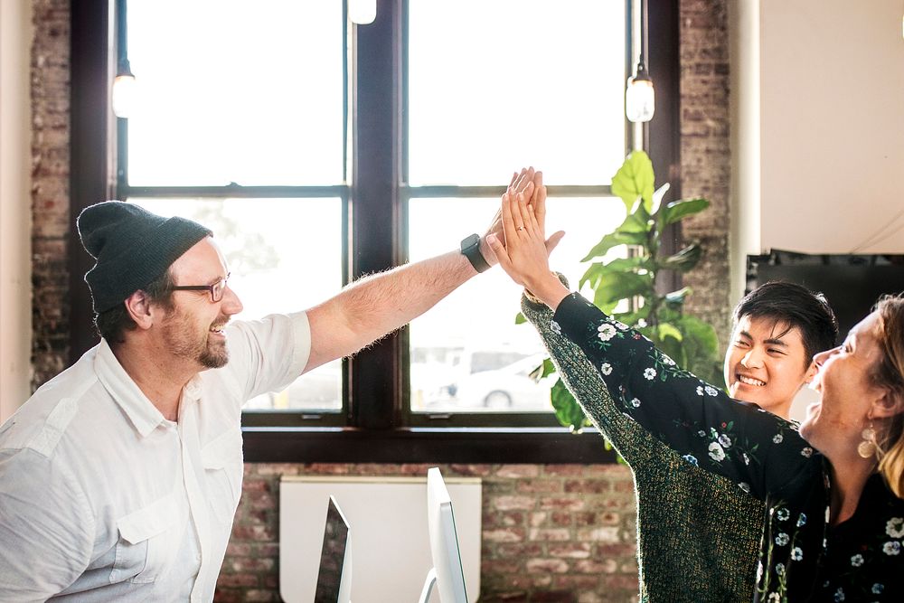 Happy diverse colleagues in a startup company doing a high five