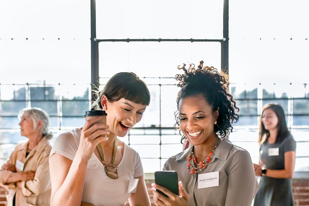 Businesswomen sharing online content from a phone