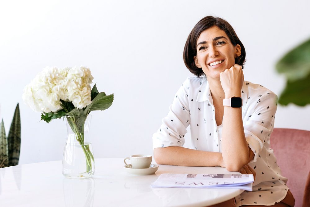 Happy woman wearing a smartwatch sitting at her desk