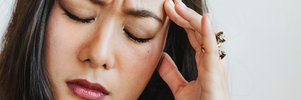 Stressed woman holding her forehead