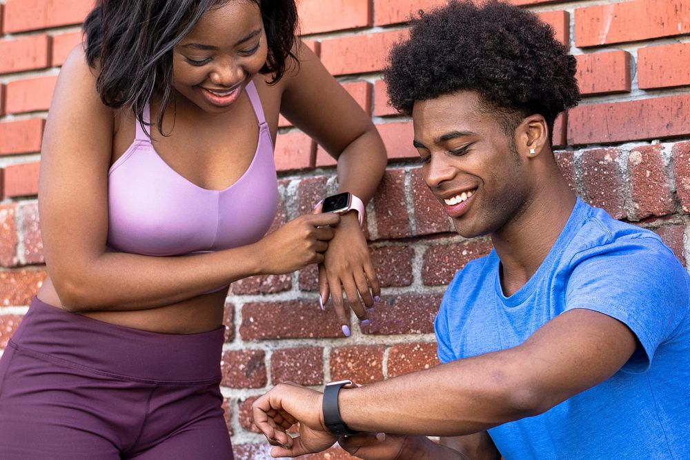Sportive couple using smartwatches