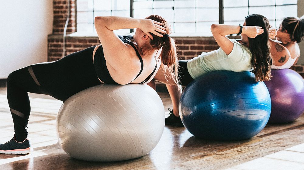 Healthy women using fitness ball for an ab workout