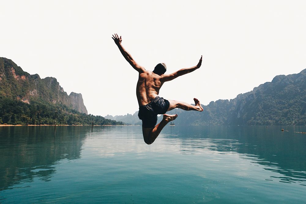 Man jumping with joy by a lake image element
