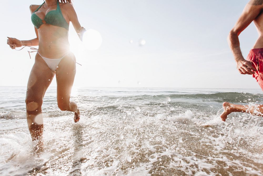 Cheerful couple running at the beach