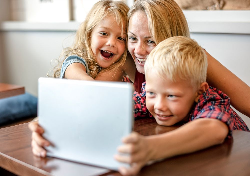 Blonde mom and kids making a video call on a tablet