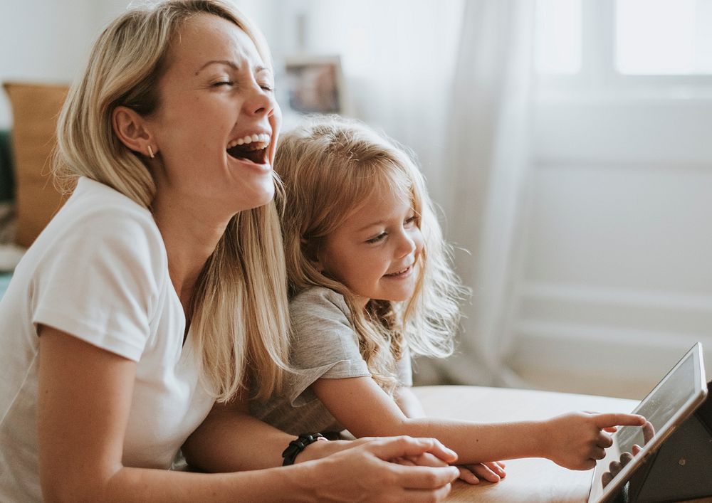 Blonde girl playing on a digital tablet