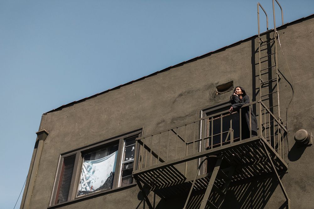 Woman standing on fire escape during the coronavirus lockdown