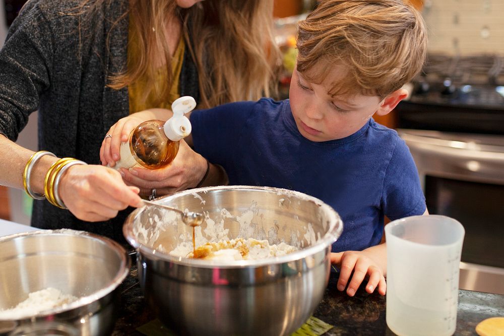 Mom teaching son how to bake in the kitchen