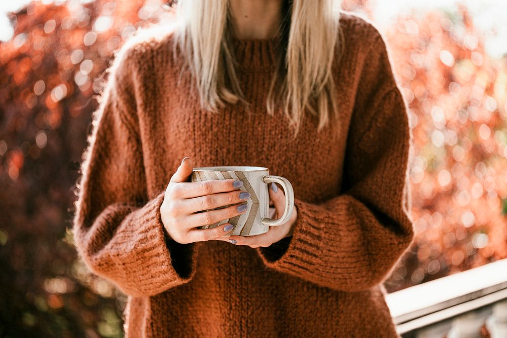 Woman drinking a cup of warm herbal orange tea