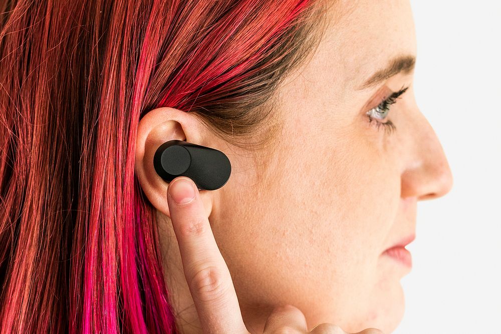 Woman with pink hair wearing wirless earbuds