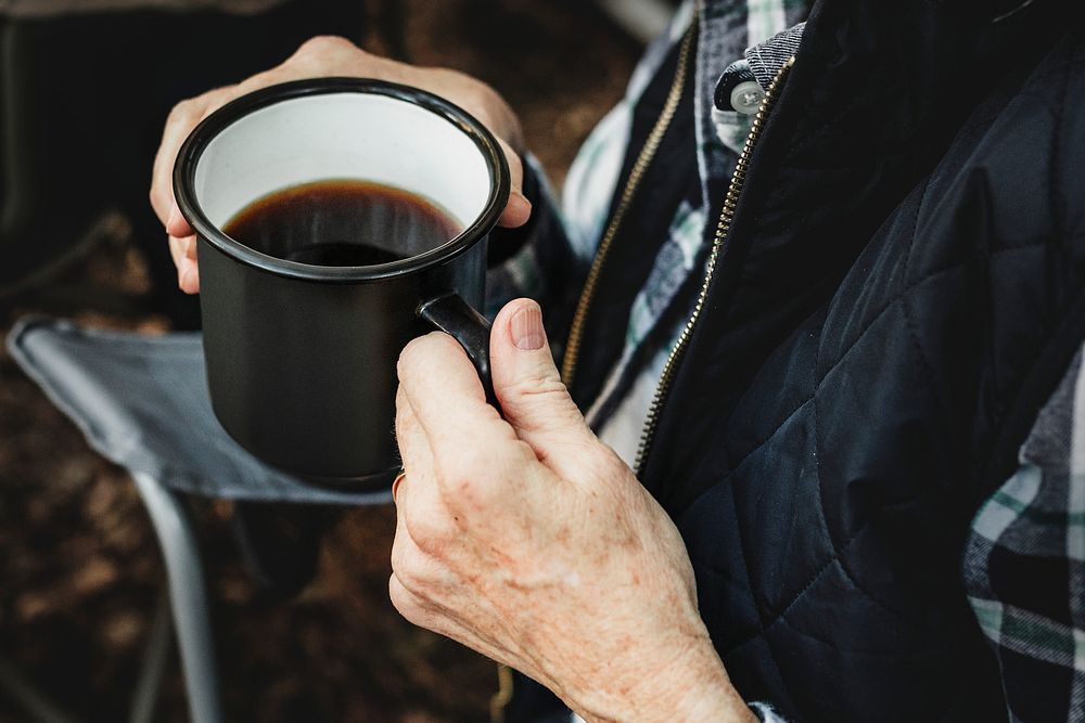 Having coffee by the tent in the forest 