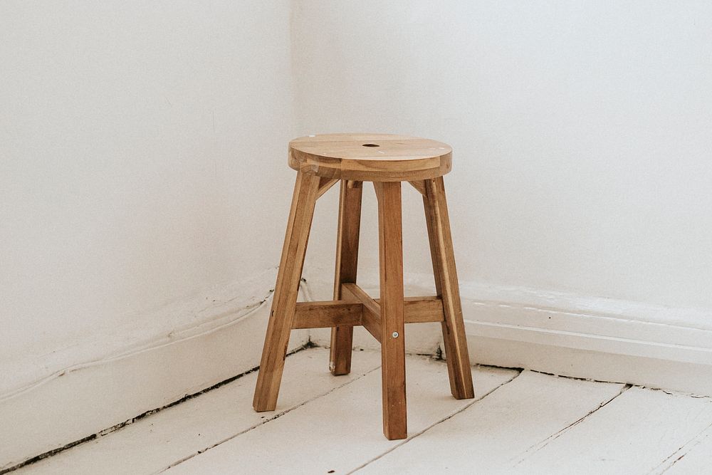 Wooden bar stool in a corner