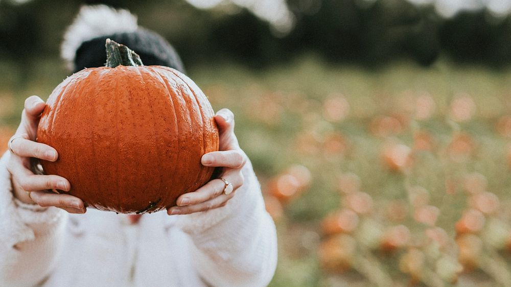 Woman at a pumpkin patch before Halloween
